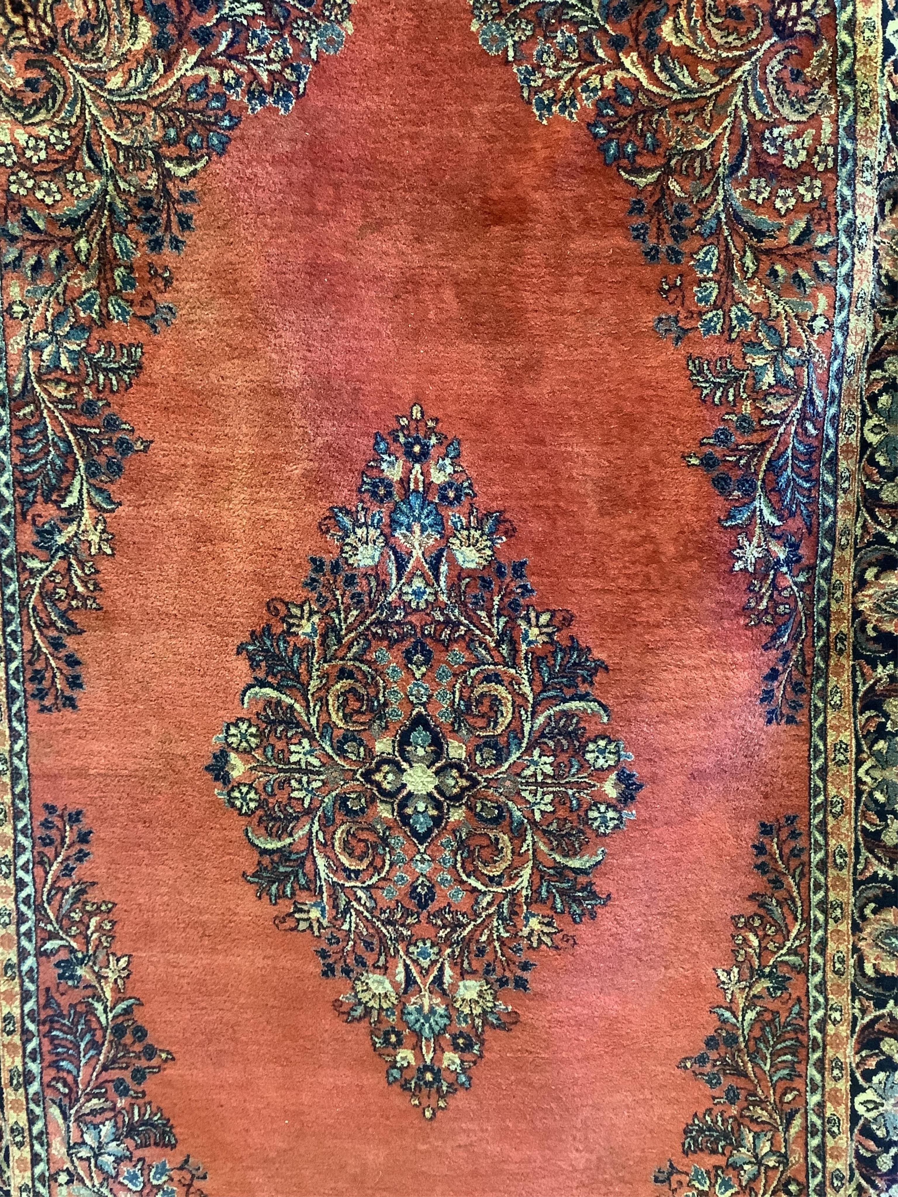 A Sarouk red ground rug, 244 x 151cm